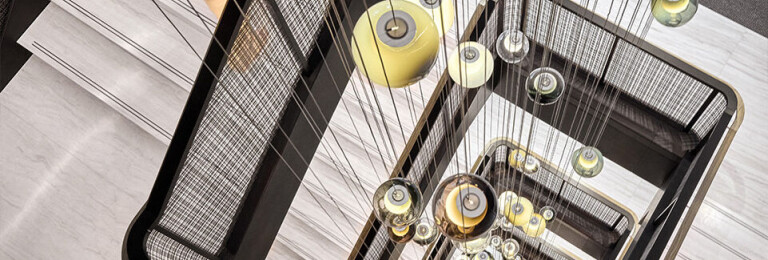 Banker SJD-21 Architectural Woven Wire Mesh in Plated Antique Brass used in Stairwell Infill Panels allowing natural light to flow through the space.