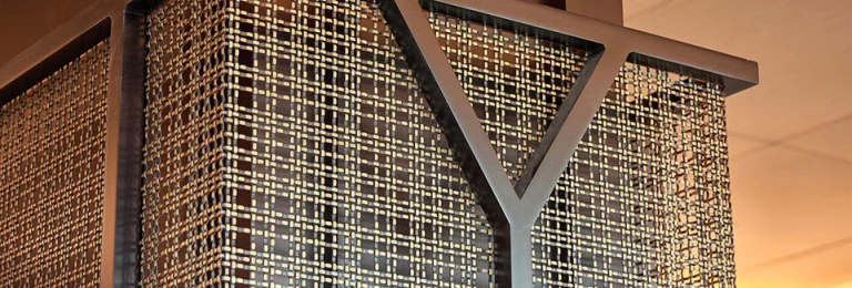 Banker SJD-21 Woven Wire Mesh reflecting light and adding a textured detail to the fireplace exhaust in a corporate office renovation.